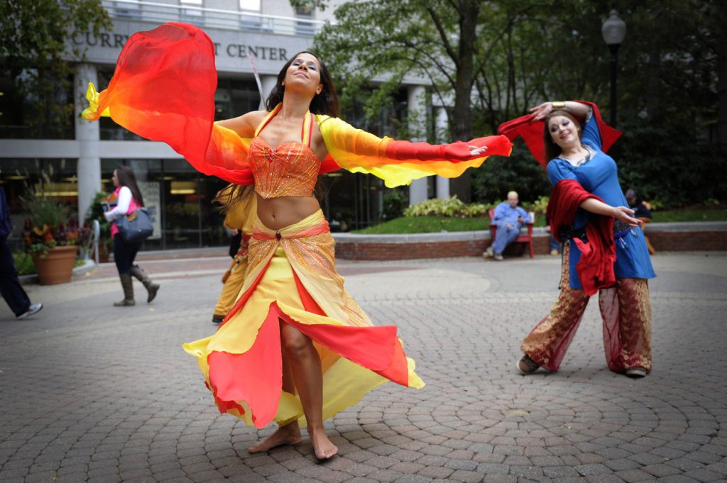 Image of 2 students dancing while in cultural dress.