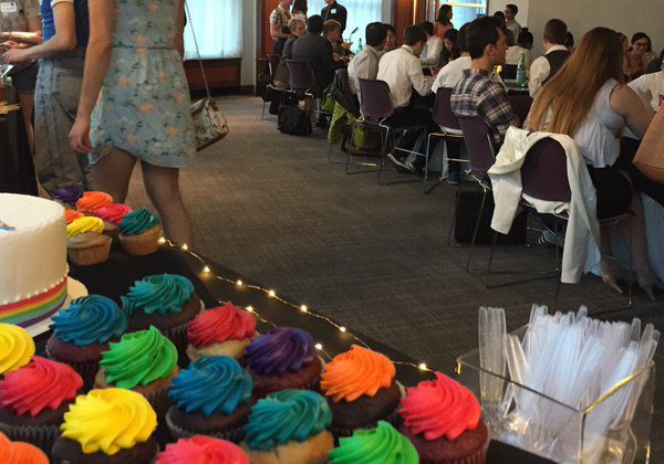 A picture from the rainbow graduation event. The image shows a dessert table with cupcakes with different color frostings.